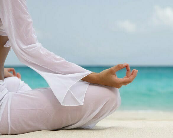 woman meditating on the beach