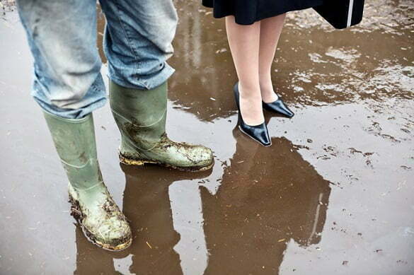 Business Woman with Farmer in Mud --- Image by © Colin Hawkins/cultura/Corbis